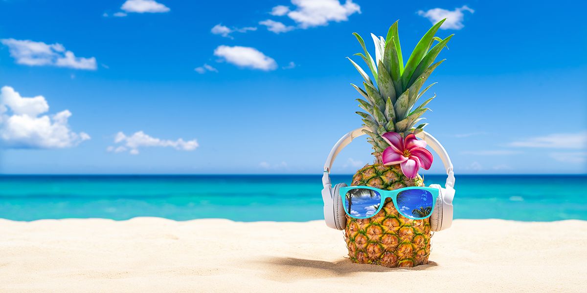PinePineapple with sunglasses and headphones at tropical beach